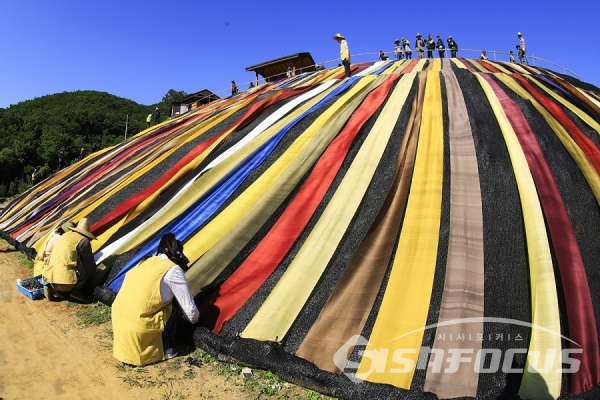 천연염색천을 보여주기 위해 서운암 언덕에 설치하는 모습. 사진/강종민 기자