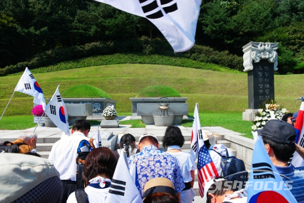 추모식 참석 시민들이 박정희 대통령과 육영수 여사 묘소에서 묵념을 하고있다. 사진/유우상 기자