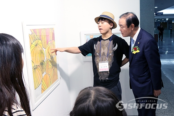 장병완 원내대표가 다문화가정의 학생이 그린 작품에 대해 설명을 듣고 있다. [사진 / 오훈 기자]