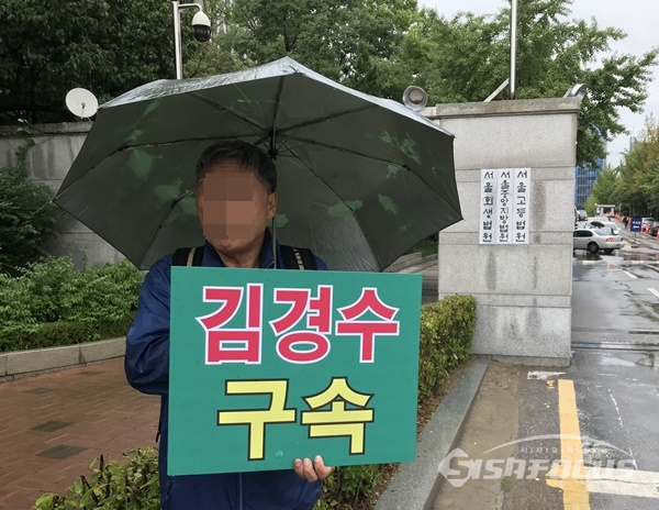 21일 오전 대한애국당 단체 한 회원이 서울 서초구 서울지법 앞에서 피켓을 들고 있다. 사진 / 김경수 기자
