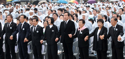 올해 제38주년 5.18 광주민주화운동 기념식에서 빗속에서 이낙연 국무총리를 비롯한 참석자들이 '임을 위한 행진곡'을 제창하고 있는 모습 / ⓒ뉴시스DB