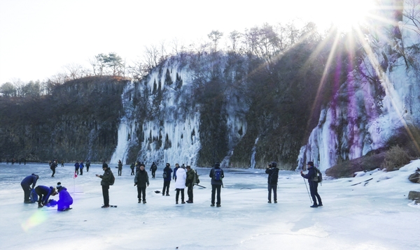 한탄강 얼음트레킹 축제장 빙벽폭포 앞에서 기념촬영을 하며 즐기는 동호인들.  사진/강종민 기자