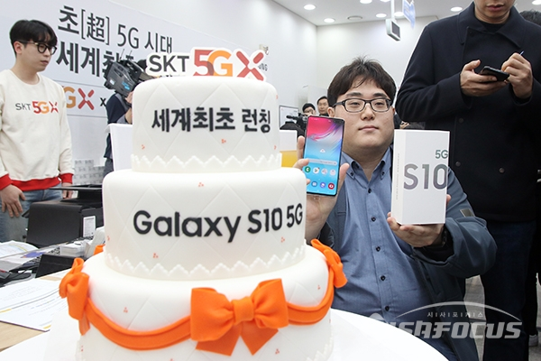 SKT 5G 일반인 최초 개통자 이유건씨가 개통된 갤럭시S10 5G를 전달받고 있다. [사진 / 오훈 기자]