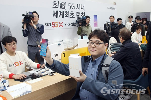 SKT 5G 일반인 최초 개통자 이유건씨가 개통된 갤럭시S10 5G를 전달받고 있다. [사진 / 오훈 기자]