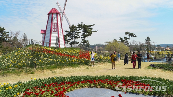 각종 조형물과 꽃를 조화롭게 조성한 꽃 축제장을 둘러보며 즐기는 관광객들 모습.  사진/강종민 기자