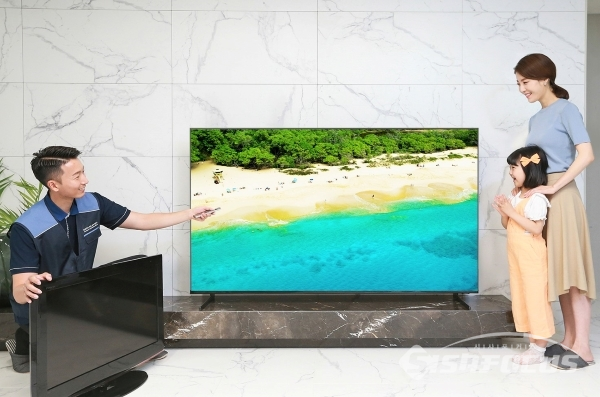 삼성전자 TV 설치기사가 '대국민 TV 보상 페스티벌'을 통해 TV를 구매한 소비자 가정에서 구형 TV를 회수하고 2019년형 QLED TV를 설치한 후 사용법을 설명하고 있다.