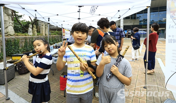 소금 제작체험에 참여하여 받은 악기를 불어보며 즐거워하는 어린이들.  사진/강종민 기자