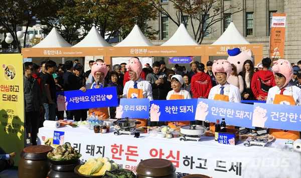 서울광장 우리돼지 한돈 살리기 행사장에서 참여자들이 돼지고기 홍보 피켓을 들고 캠페인을 펼치는 모습.  사진/강종민 기자