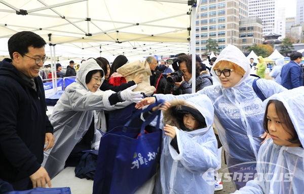 서울광장에서 열린 '어서와, 겨울은 처음이지?' 외투나눔 행사에서 외국인들이 고른 외투를 포장해서 나누어주는 모습.  사진/강종민 기자