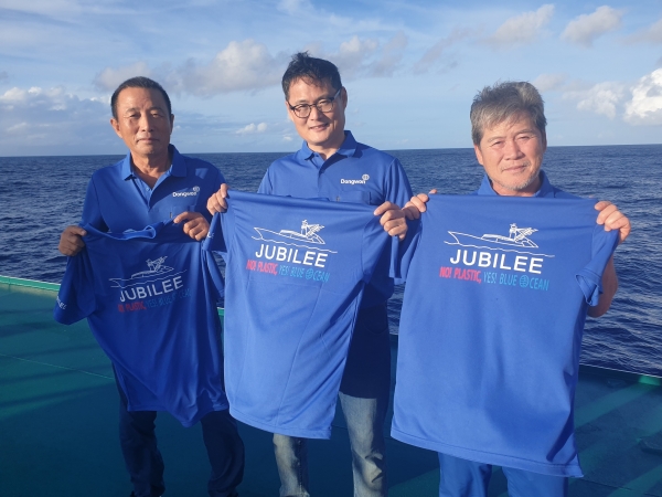 남태평양에서 조업중인 김민호 동원산업 주빌리호 선장(가운데)과 선원들이 '플라스틱 저감화 3개년 계획'의 슬로건 “No! Plastic! Yes! Blue Ocean!”이 적힌 티셔츠를 들고있다. ⓒ동원산업