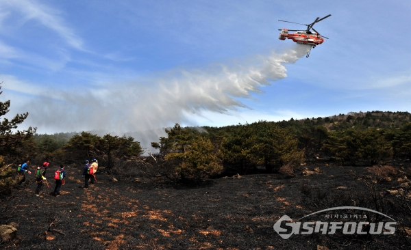 2012년 한라산국립공원내 산불로  관계 공무원과 소방헬기가 지상과 하늘에서 입체적으로 진화에 나섰다.사진/제주지방경찰청