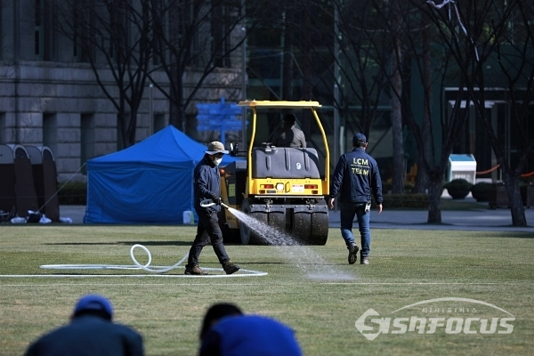 서울시 관계자들이 새 잔디를 깔고 있다. [사진 / 오훈 기자]