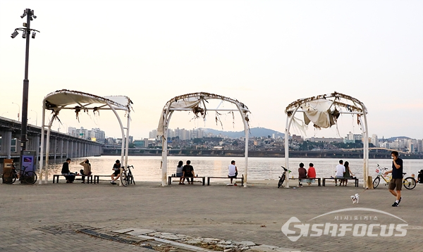 아직 복구되지 않은 한강공원 쉼터에도 많은 시민들이 휴식을 취하고 있다.  사진/강종민 기자