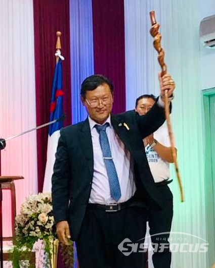 볼리비아 대선후보인 한국계 정치현 후보가 부친인 정은실 목사로부터 모국인 전남 순천의 정태중 목사가 손수 깎아만든 '모세의 기적의 지팡이'를 전달 받고 선거승리를 기원하며 지팡이를 높이 치켜들고 있다. 제공=순천 드림교회 임화식 목사