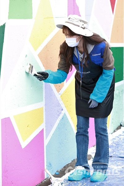 가수 하니가 벽화 그리기 봉사활동을 하고 있다.