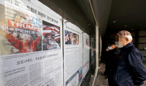 시민들이 미국 대선 상황을 분석하고 있는 국내 언론들의 신문 게시판을 바라보고 있다 / ⓒ뉴시스DB