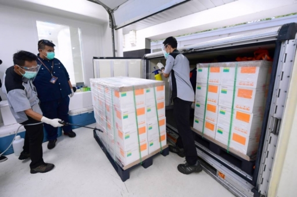 7일(현지시간) 인도네시아 반둥에 있는 국영 제약사 바이오파마 관계자들이 이날 도착한 중국 시노백의 코로나19 백신 상자들을 소독하고 있다. ⓒ뉴시스