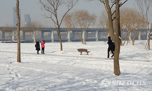 한강변 설경을 핸드폰에 담으며 즐겁게 산책하는 시민들 모습.  사진/강종민 기자