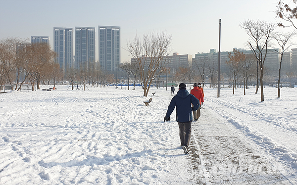 한강공원 설경을 보니 눈이 호강하는 기분이라는 아침 산책길 시민들 모습.  사진/강종민 기자