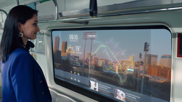 LG디스플레이의 ‘지하철 윈도우용 투명 OLED’를 통해 바깥 풍경을 보는 동시에 운행스케줄, 위치정보, 일기예보나 뉴스와 같은 생활정보를 살펴보고 있는 모습. ⓒLG디스플레이