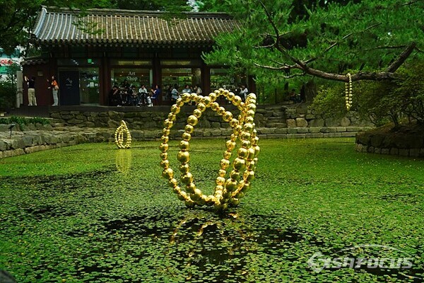 덕수궁 연못에 전시중인 장-미셀 오토니엘의 황금빛 구슬조각 작품. 사진/유우상 기자