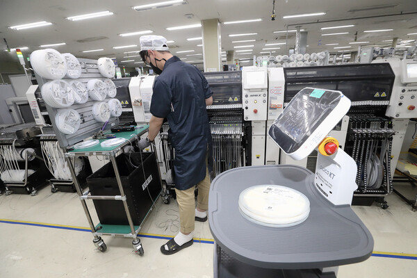 경기 평택시 대성엘텍 생산공장에서 직원이 KT AI 서비스로봇이 배송한 부품을 받아 제조 공정을 이어가고 있다. ⓒKT