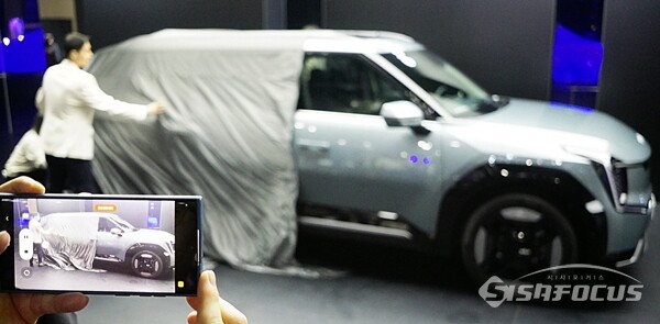 기아 EV9이 세계 최초로 실물 차량이 공개되는 순간을 담고 누군가가 핸드폰으로 촬영하고있다. 기아 1분기에 영업익 2조8740억 원을 기록했다. (사진 / 강민 기자)
