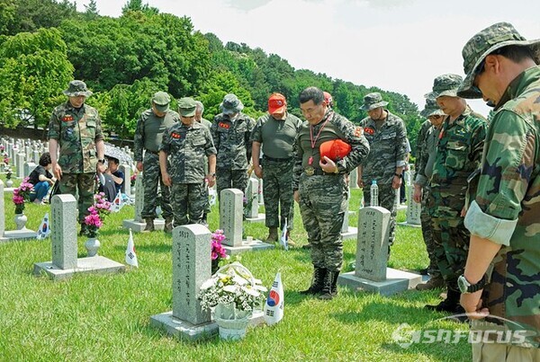 50여 년전 월남전에서 산화한 해병전우에게 생존병사와 후배들이 묵념하고 있다. 사진/유우상 기자