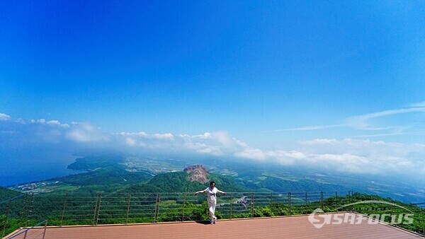 케이블카 타고 올라온 관광객이 멀리 쇼와신산을 배경으로 인증샷을 찍고 있다.  사진/유우상 기자
