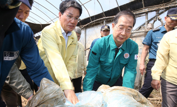 한덕수 국무총리가 19일 집중호우로 인해 수해를 입어 특별재난지역으로 선포된 충남 청양군 청남면 인양리를 찾아 현장을 살펴보고 복구작업을 돕고 있다 / ⓒ국무조정실