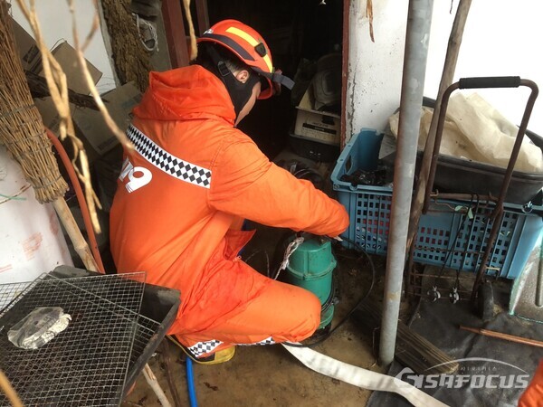 지난 14일 공주시 옥룡동 침수피해 주택에 출동한 소방관이 배수 작업을 하고 있다. (사진 / 충남소방본부)