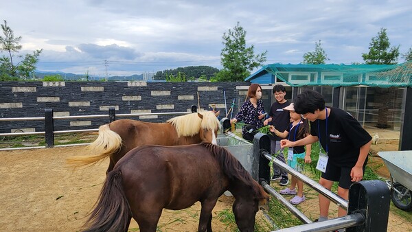  ‘우리가족 힐링 숲 나들이’ 에 참여한 학생들이 동물교감 체험을 하고 있다.사진/엄명숙 기자