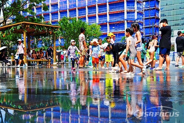 29일 오후 어린이들이 광화문광장 분수에서 나오는 시원한  물줄기를 맞으며  물놀이를 즐기고 있다.  사진/유우상 기자