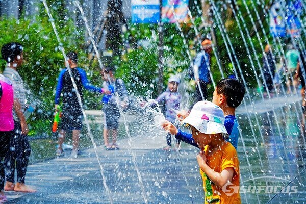 29일 오후 어린이들이 광화문광장 분수에서 나오는 시원한  물줄기를 맞으며 물놀이를 즐기고 있다. 사진/유우상 기자