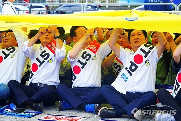 민주당 이재명 대표와 최고위원들이  용산 전쟁기념관 정문 앞에서 핵물질을 의미하는 노란  대형 천을 가위로 찟는 퍼포먼스를 하고 있다. 사진/유우상 기자