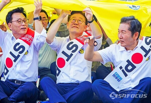 25일 오전 서울 용산  전쟁기념관 정문 앞, 집회에 참석한 민주당 이재명 대표의 얼굴 표정을  담아보았다.  핵 물질을 의미하는 노란 대형 천을 가위로 찟는 퍼포먼스를 하고 있다.  사진/유우상 기자