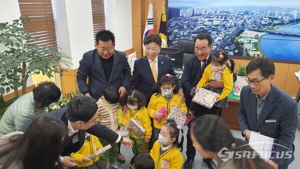 의장실에서 의회 사무국으로부터 방문 기념 선물을 전달 받는 어린이들과 하의장이 어린이를 안고 함박웃음을 보이는 모습.사진/김진성 기자