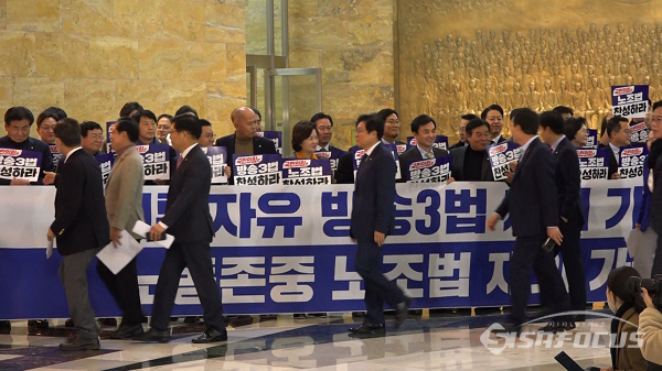 국민의힘 의원들이 8일 오후 서울 여의도 국회 본회의장 앞에서 더불어민주당 의원들이 피켓팅하는 앞을 지나가고 있다. 사진 / 김경민 기자