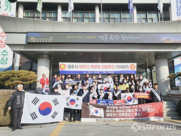 태극기게양대 설치 촉구 기자회견에 참여한 시민단체회원들이 태극기를 들고 있는 모습. 사진/김대섭 기자