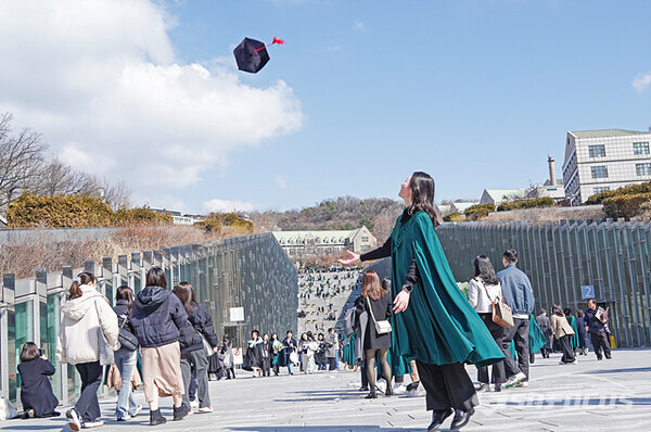 26일 서울 신촌 이화여대에서 졸업생이 학사모를 하늘 높이 던지며 학위 수여를 자축하고 있다. 사진/유우상 기자