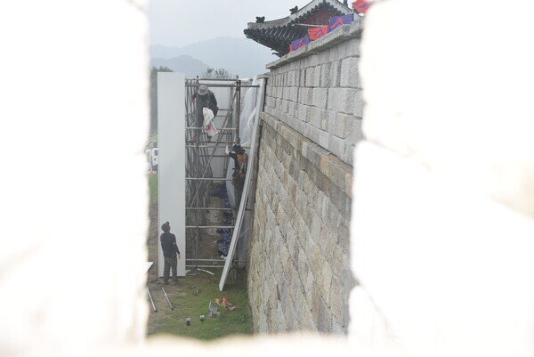 18일 주민들이 부실공사로 인한 인재라고 주장하는 성주읍성의 성곽 일부가 호우로 붕괴되자 인부들이 안전장비도 없이 긴급 가림막 설치 공사를 하고 있다. 사진 / 김진성 기자 