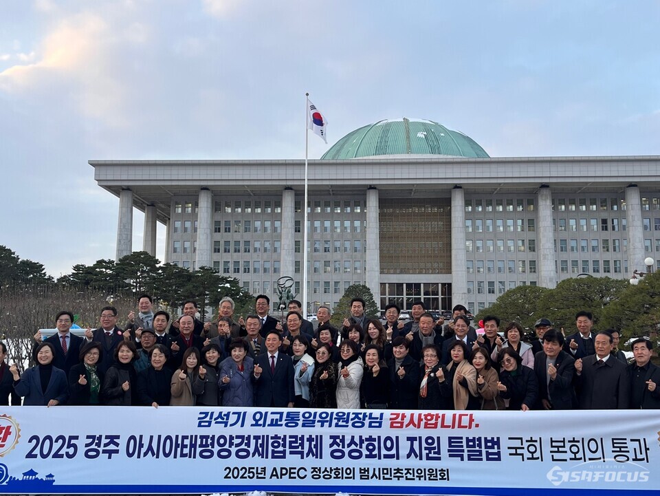 28일 서울 여의도 국회 본관 앞에서 김석기 위원장과 시민들이 ‘2025 경주 APEC 정상회의 지원 특별법’ 통과를 축하하며 기념촬영을 하고 있다. 사진 / 경주