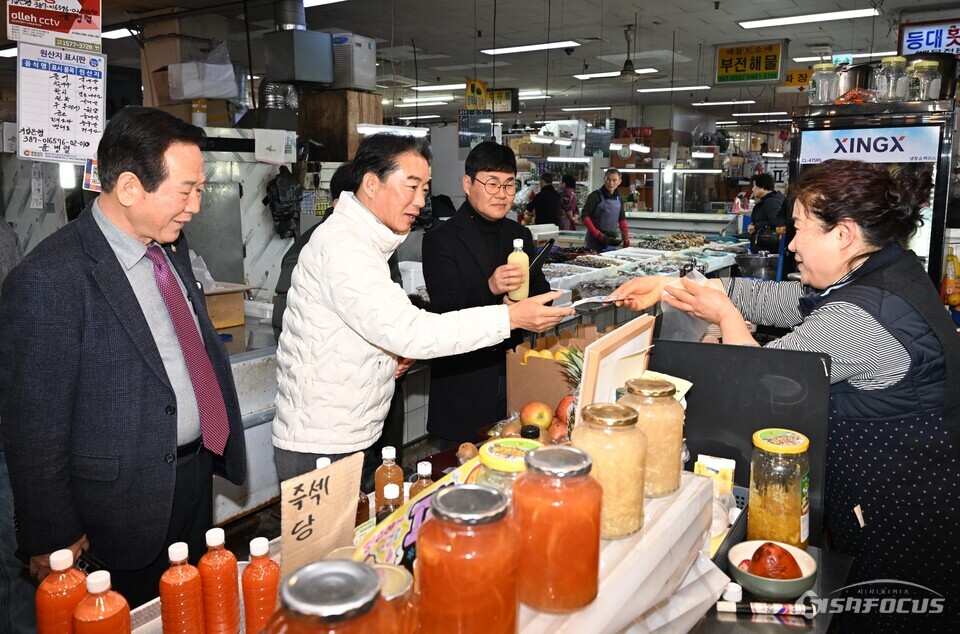 최학범 경남도의회 의장이 14일 김해주촌축산물시장에서 직접 물건을 구입하며 전통시장 활성화를 위한 소통에 나서고 있다. 사진 / 경남도의회