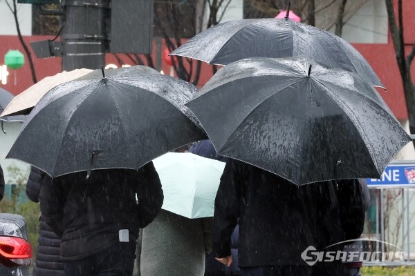 5일 우산과 우비를 쓴 시민들이 이동하고 있다.(1)