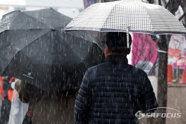 5일 우산과 우비를 쓴 시민들이 이동하고 있다.(2)