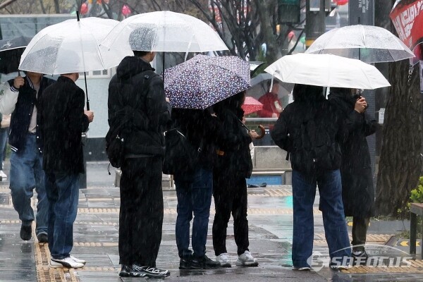 5일 우산과 우비를 쓴 시민들이 이동하고 있다.(4)