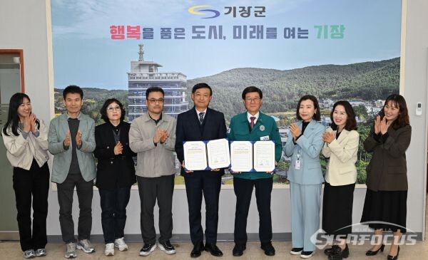 8일 기장군청에서 열린 ‘기장 안부살핌 우편 서비스 사업’ 업무협약식에서 정종복 기장군수(왼쪽에서 다섯번째)와 박영선 기장우체국장(왼쪽에서 네번째)이 협약서를 들고 기념촬영을 하고 있다. 사진 / 기장군