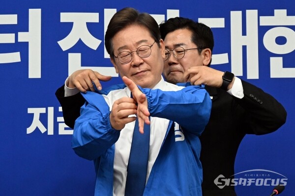 박찬대 더불어민주당 대표 직무대행 겸 원내대표가 지난달 28일 서울 영등포구 여의도 국회 본청에서 열린 최고위원회의에서 이재명 대선 후보에게 선거복을 입혀주고 있다. 사진 / 오훈 기자