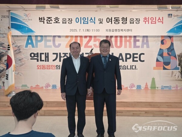 박준호 전 읍장(좌)과 여동형 신임 읍장(우)이 손을 맞 잡고 기념촬영 하는 모습. 사진/김인철 기자