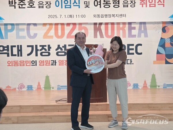 박준호 전임 읍장에게  직원 대표가 감사의 뜻으로 사랑이 듬뿍 담긴 꽃다발과 초대형 왕뚜껑 라면을 선물하는 모습. 사진/김인철 기자